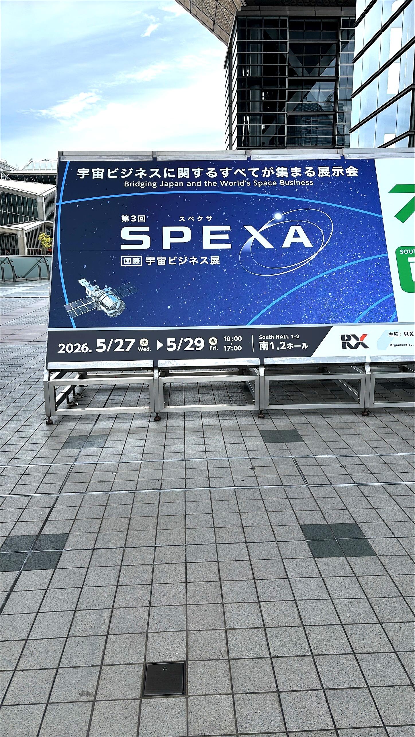 第3回SPEXA国際宇宙ビジネス展の看板。「宇宙ビジネスに関するすべてが集まる展示会」と書かれ、開催期間2026年5月27日〜29日、東京ビッグサイト南1・2ホールと記載されている。